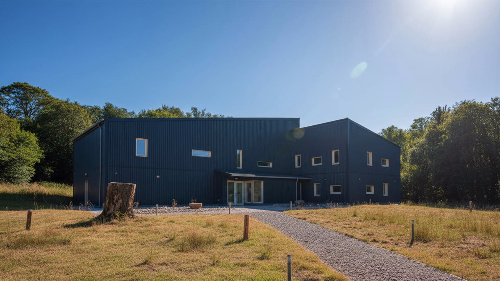 Mull Theatre building, shown on a sunny day with its modern exterior, clean lines, and surrounding greenery under clear skies.