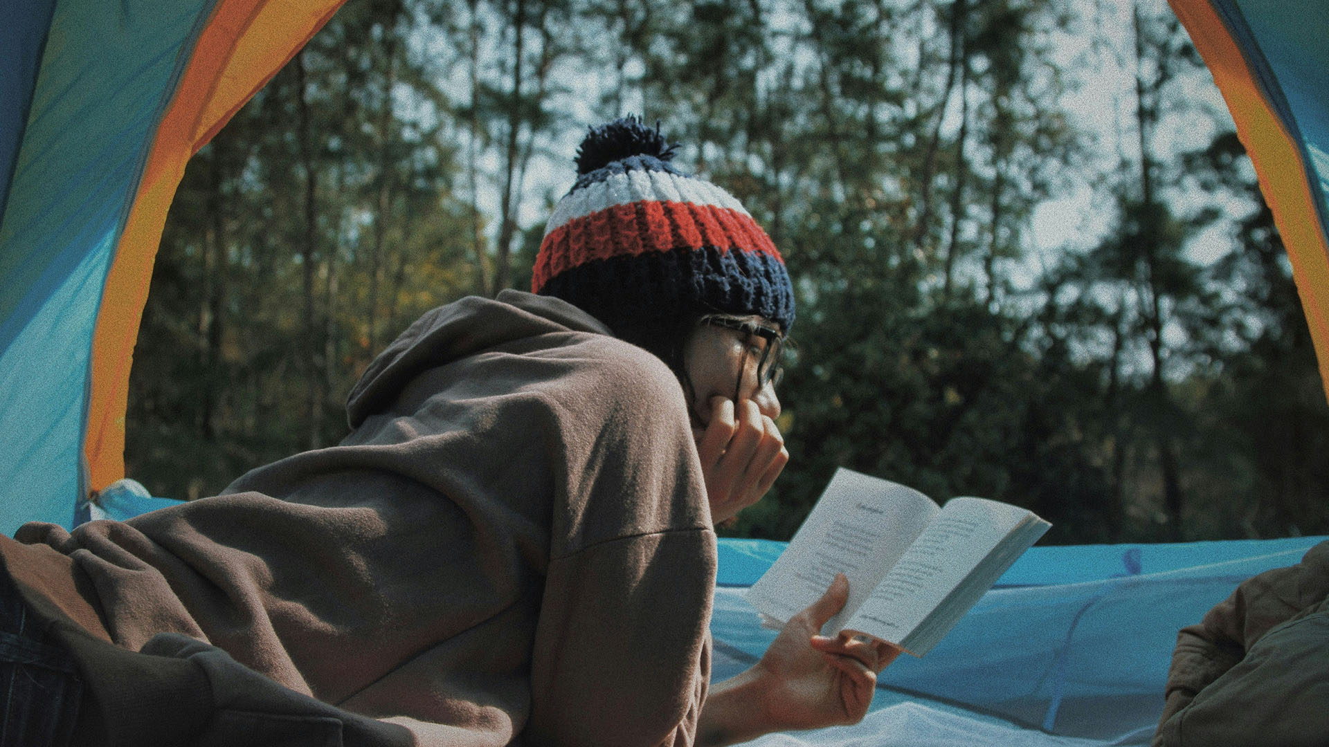woman reading in a tent